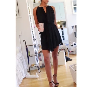  - Svart klänning med gulddetaljer i fint skick. Knyts med skärp runt midjan och är därför en "one size". Jag är 168cm. Kan hämtas i Uppsala eller fraktas men då står köparen för fraktkostnad 🌸