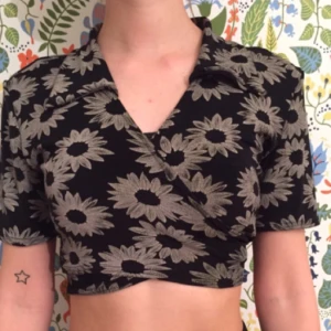  - Jättefin och cool knit-blus med grå blommor på svart bakgrund. Croppad och med en diskret krage. 🦇