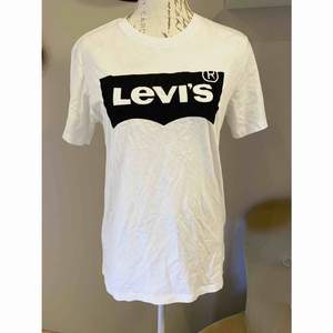 Vit t-shirt med svart tryck från Levis. Trycket är som mjukt. Den är i storlek S, oanvänd. 