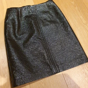  - Supersnygg svartlackad kjol från Lindex. Helt ny, prislapp kvar där det står 299 kr. Kan mötas upp i city. Fri Frakt även.