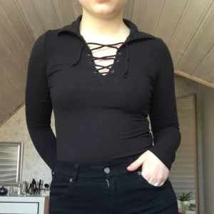  - En tight, svart långärmad med knyte där fram!  Den har en ”krage” precis vid knytena.  Kommer tyvärr inte till användning längre - därför säljer jag den! 🌹