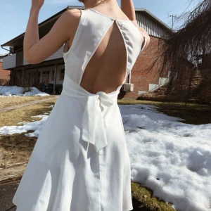  - En superfin sommarklänning i vitt. Med öppen rygg och band att knyta bak eller fram. Använd 2 gånger. Den har en liten reva vid knäppningen baktill, se bild 3 (: 