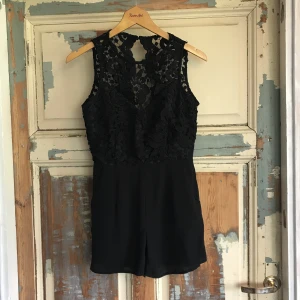  - Romantisk byxdress med grov spets och öppen rygg. Aldrig använd då den är väldigt liten i storleken. Snarare XS än S. 