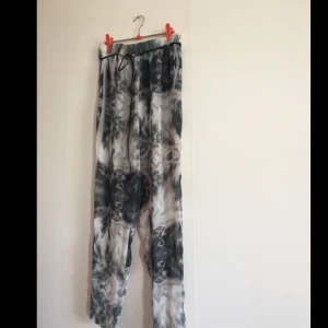  - Fräsiga tunna sommarbyxor!  Jättesnyggt mönster i svart och grå/blåa palmblad och fjärdar. Liten riv skada i överkant, se sista bild. 