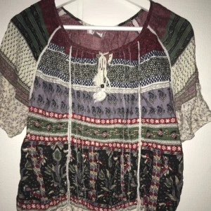  - Superfin skön blus med mönster och ”tofsar” framtill som man kan knyta eller låta hänga lösa. Oanvänd!😊