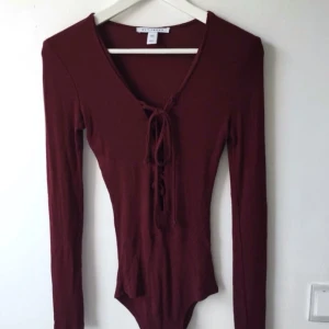  - Body med knäppning mellan benen och knytning där fram. Från NLY trend. I fint skick, använd en gång. Passar även en S.  Frakt tillkommer.