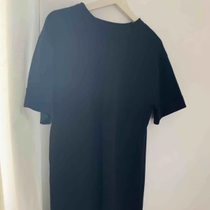 - Svart T-shirt klänning i ett lite tjockare material. Oanvänd pågrund av fel strl. Men perfekt lång för mig som är 167 cm lång.