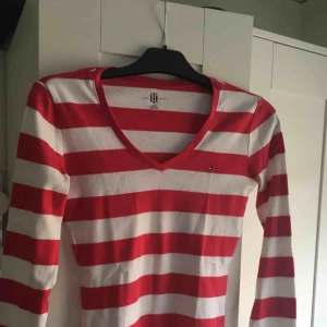  - En rosa-vit randig långärmad tröja från Tommy hilfiger! i storlek XS och i bra skick !  Kontakt: 0732500530(nås på sms) Teamarkholm@gmail.com  Köparen står för frakt! 🥰