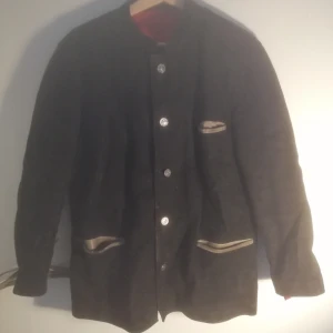  - Svart mockajacka.  Mått: Höjd 70 cm Bredd (axel till axel) 45 cm  Pris: 300 kr