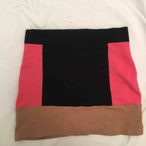  - Tubkjol med en tjock rosa rand på varje sida, även en beige rand rund hela kjolen.