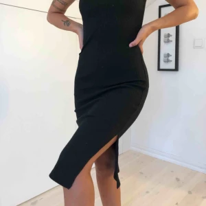  - Svart klänning med polokrage och slits på sidorna. Väldigt skön & stretchig i tyget