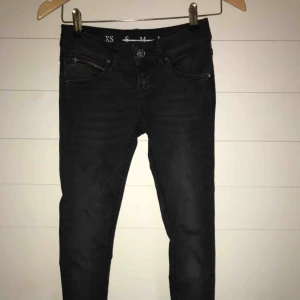  - Svarta never denim jeans, lågmidjade, väldigt stretchiga, inte använda!