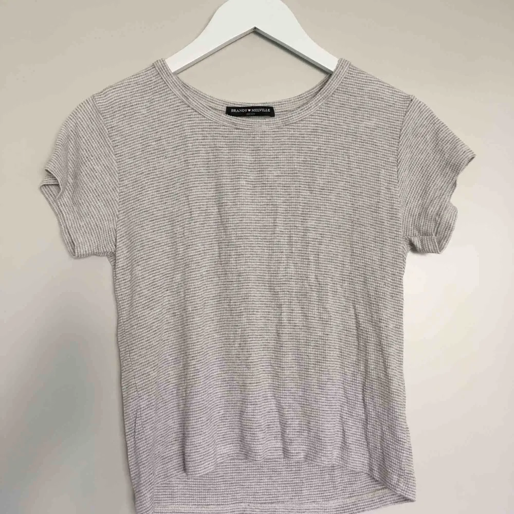 Grå vit randig T-Shirt med mkt stretchigt material som passar alla storlekar från S-XL. Aldrig använd och är i mkt bra skick . T-shirts.