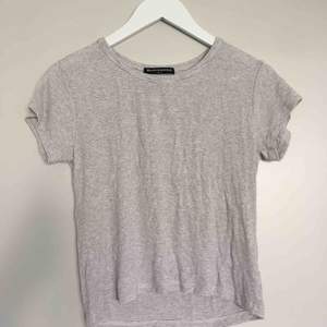 Grå vit randig T-Shirt med mkt stretchigt material som passar alla storlekar från S-XL. Aldrig använd och är i mkt bra skick 