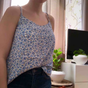  - Luftigt sommarlinne från Hm i blåblommigt mönster. Axelbanden är justerbara i längd.  Superfint!