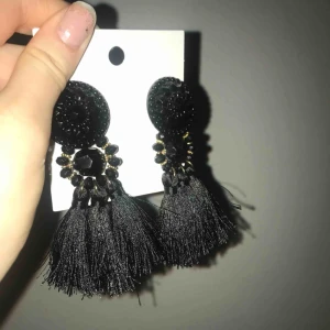 - Svart Örhängen med tofsar och guldiga detaljer 💞