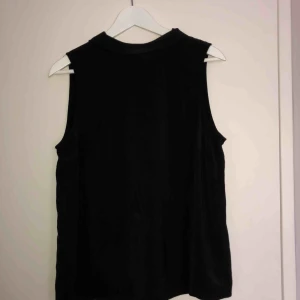  - Snyggt svart linne med krage och dragkedja på baksidan. 