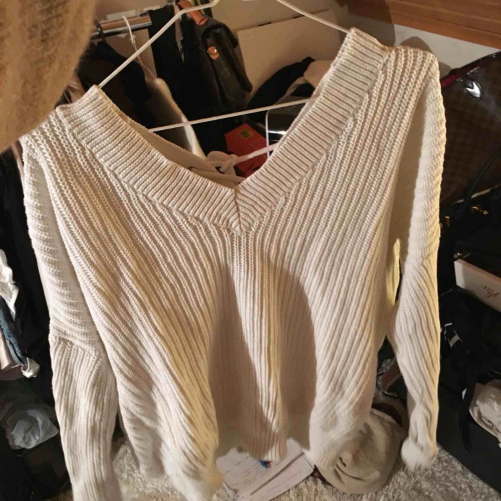 Super fin vit stickad tröja med öppen rygg! Köpt från Nelly för 399 kr. Säljs då den ej kommer till användning! Super fint skick! . Tröjor & Koftor.