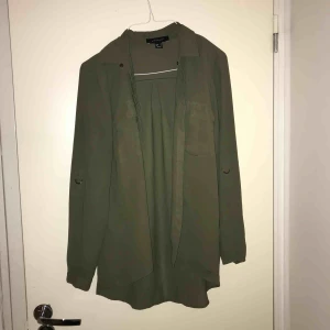  - Blus/skjorta i militär grönt.