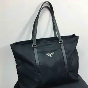 Prada Black Tessuto Nylon Tote Bag. Excellent condition exterior. The interior has been professionally repaired. One internal pocket. 12.75