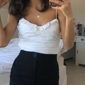 Vit topp med detaljer - Använd endast 2 gånger och toppen är i bra skick! Detaljer framtill och baktill. 