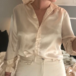 Silkes skjorta - Konstsilkesskjorta i champagne färg köpt på second hand i fint skick! Tyvärr för liten för mig så därför jag säljer! I storlek 34 men skulle passa en 36 med :) frakt 22