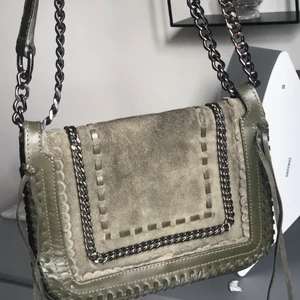 Zara mörkgrön axelväska/cross-body väska - Jag säljer en mörkgrön axelväska med mörkgråa detaljer och fransar på sidorna. Jag köpte den på Zara för 2 eller 3 år sedan för ca 400kr och har bara använt några fåtal gånger!