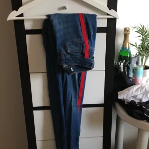 Blåa jeans med röda streck - Blåa jeans med röda streck från gina Tricot i storlek S, Molly high waisted (lappen är avklippt) nypris är 500kr, frakt tillkommer💕