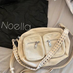 noella väska  - (BUDA FRÅN 100kr!!)(BUDET PÅ 330kr)(FRAKTEN INGÅR INTE I PRISET DU BUDAR! 🤍🤍 Säljer denna beige noella väska! Den är i färgen ”off white” (beige), men har även tillkommit några mörkare partier på väskan, dock går det säkert att tvätta rent(jag har inte försökt) Har även bara använt denna väska 3 ggr!! Mått: H: 15 cm, L: 25 cm, B: 7 cm 