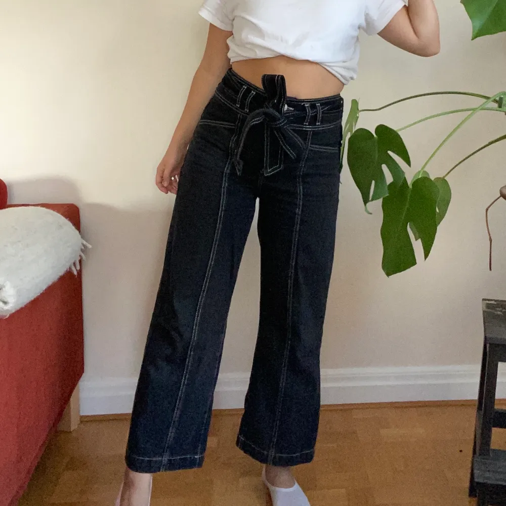 Fina svarta jeans med vita sömmar och tillhörande skärp!🖤 Jag är 1.60!. Jeans & Byxor.