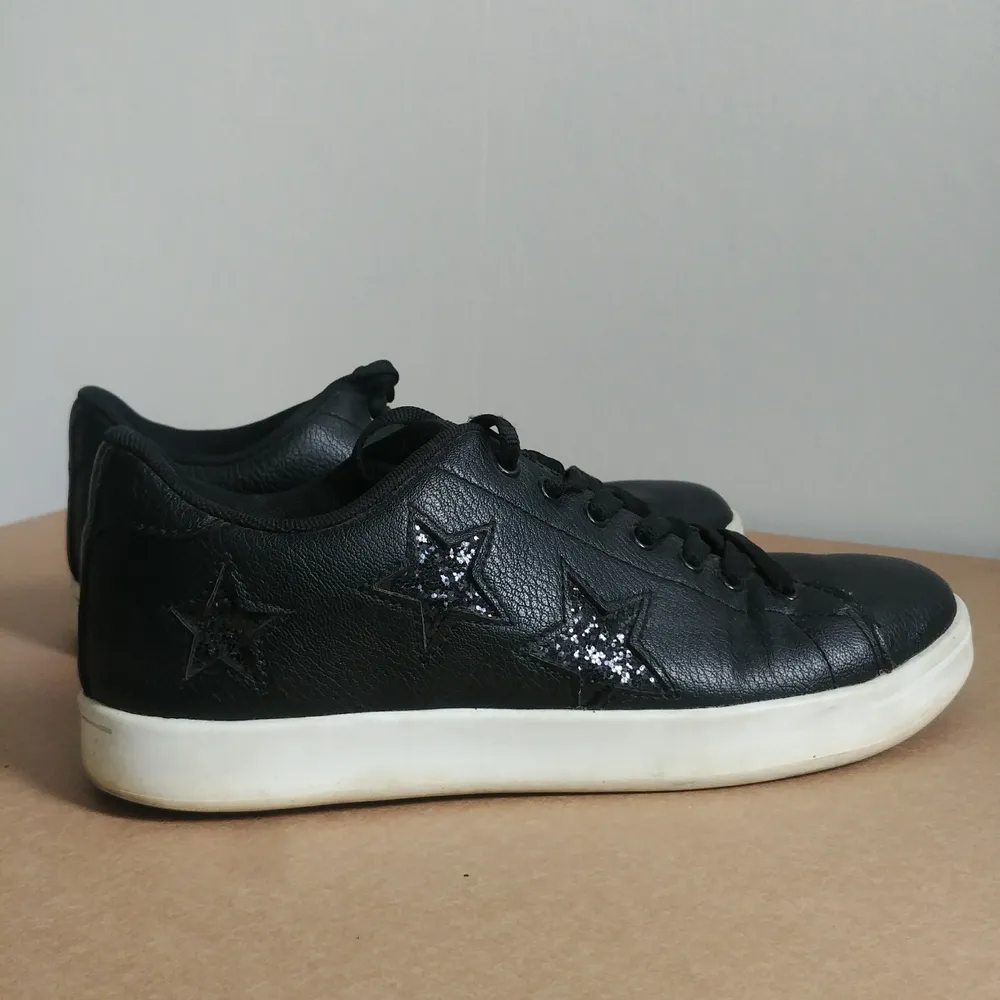 Svarta sneakers i skinnimitation med coola stjärnor på sidorna, strl 40, sparsamt använda och därmed i bra skick. Skor.