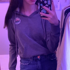 Hollister tröja med mysig lyva - En grå Hollister tröja med stor mysig lyva och detaljer på armen och en Hollister logga på bröstet i storlek S.