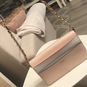 Guess väska - En vit och rosa guess väska. Lite missfärgad, använt skick. Ordinarie pris 900. Säljer för 145 köparen står för frakten!!