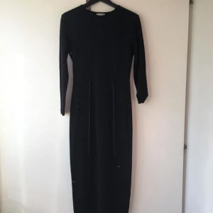  - Svart vintage långklänning i tjock material med sammet-snören framtill som man kan knyta! Säljer pga aldrig använder den! Mycket bra skick! Köparen står för frakten! Tar även emot betalning via swish!