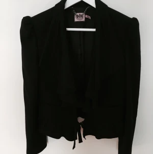  - Kavaj med volang från Juicy Couture. 

Den är kort och har ett litet band som man kan knyta framtill. 