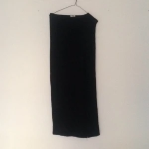  - Svart långkjol från weekday. Hög skurning på ena sidan. Litet hål vid ens knät.
