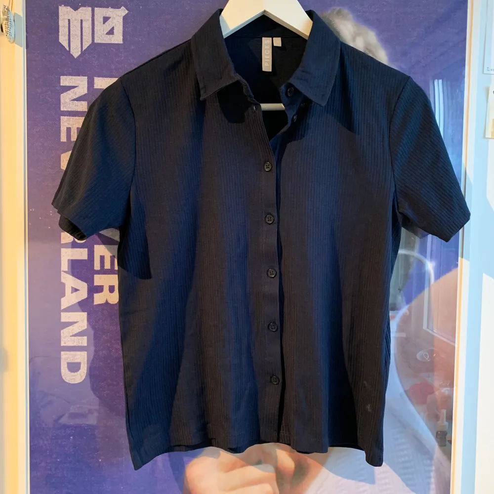 Marinblå kortärmad skjorta i S, passar även XS. Ribbad. Aldrig använd, endast testad!. Toppar.
