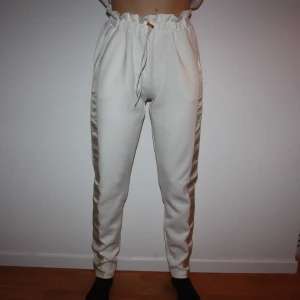 Vita byxor mjukis BIKBOK XS - Vita byxor med beige rand på sidorna från BIKBOK. Storlek XS. Väldigt mjuk! Lite scuba tyg. Endast använd 1 gång. Nypris 399:-