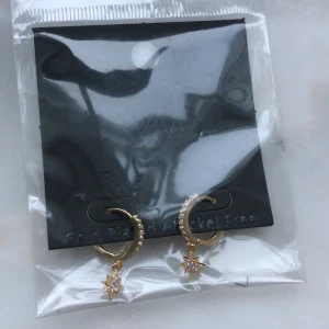 Örhängen med ”stjärnor” - Köpte från ett UF-företag i våras men har inte ens öppnat förpackningen så tänker att det är bättre att sälja vidare. Har ett par likadana i silver -> andra bilden för att se närmre. Rostfritt stål som är guldplätterat så det är kvalité. Frakt på 12kr tillkommer<3