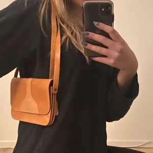 Orange väska - Söt orange väska. Går att reglera banden om man vill. 