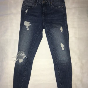 Blåa jeans med slitningar - Blåa jeans med slitningar från Only, strl W26L30 men skulle säga ca XS (kortare i modellen). Köpare står för frakt