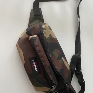 Midjeväska i camo - Riktigt snygg mideväska. Den är både smidig eftersom det finns många fack och man kan göra sjukt snygga outfits med den. Jag har bara använt den en gång och det är på mitten bilden. Använder inte den för att har så mycket andra väskor❤️FRAKT DISKUTERAS