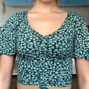 Blommig topp - Använd ett fåtal gånger. Går att justera i mitten om man vill ha mindre eller mer täckande. Säljer pga att den inte kommer till användning:/ Passar större storlekar än XS då den är stretchig. +jätteskönt material.  Köparen står för frakten😉