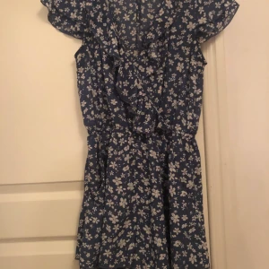 Byxdress - Blå byxdress med blommigt mönster i vitt. 