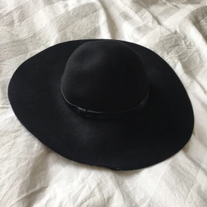 Svart hatt  - Jättefin svart hatt i filtmaterial. Aldrig använd. Storlek 58.