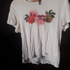 Vit t-shirt  - Gullig t-shirt med blommor på och texten "power within". Tunnare tyg. 