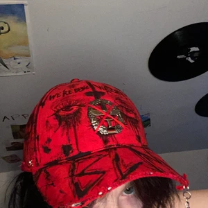 Keps Stl L/58 - Egendesignad keps med en pin från tysklands flygvapen på huvet. Orginellt så satt den på en av deras hattar så denna keps är unik. Egendesignad märke: We're Being Watched