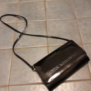  - Secondhand retro lackväska med svart snakeskinmönstrad detalj! Många fack och mycket plats. Bandet är avtagbart. Frakt: Uppsökes billigaste alternativ👍