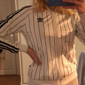  - Cool adidaskofta!!! Använd, men i bra skick! Skulle säga att den bäst passar storlek 34-36. Stort adidastryck på ryggen. Kan mötas upp i Stockholm eller så står köparen för frakten