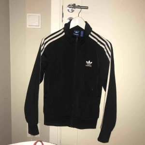  - Adidas track jacket i glansigt material. Inga defekter.